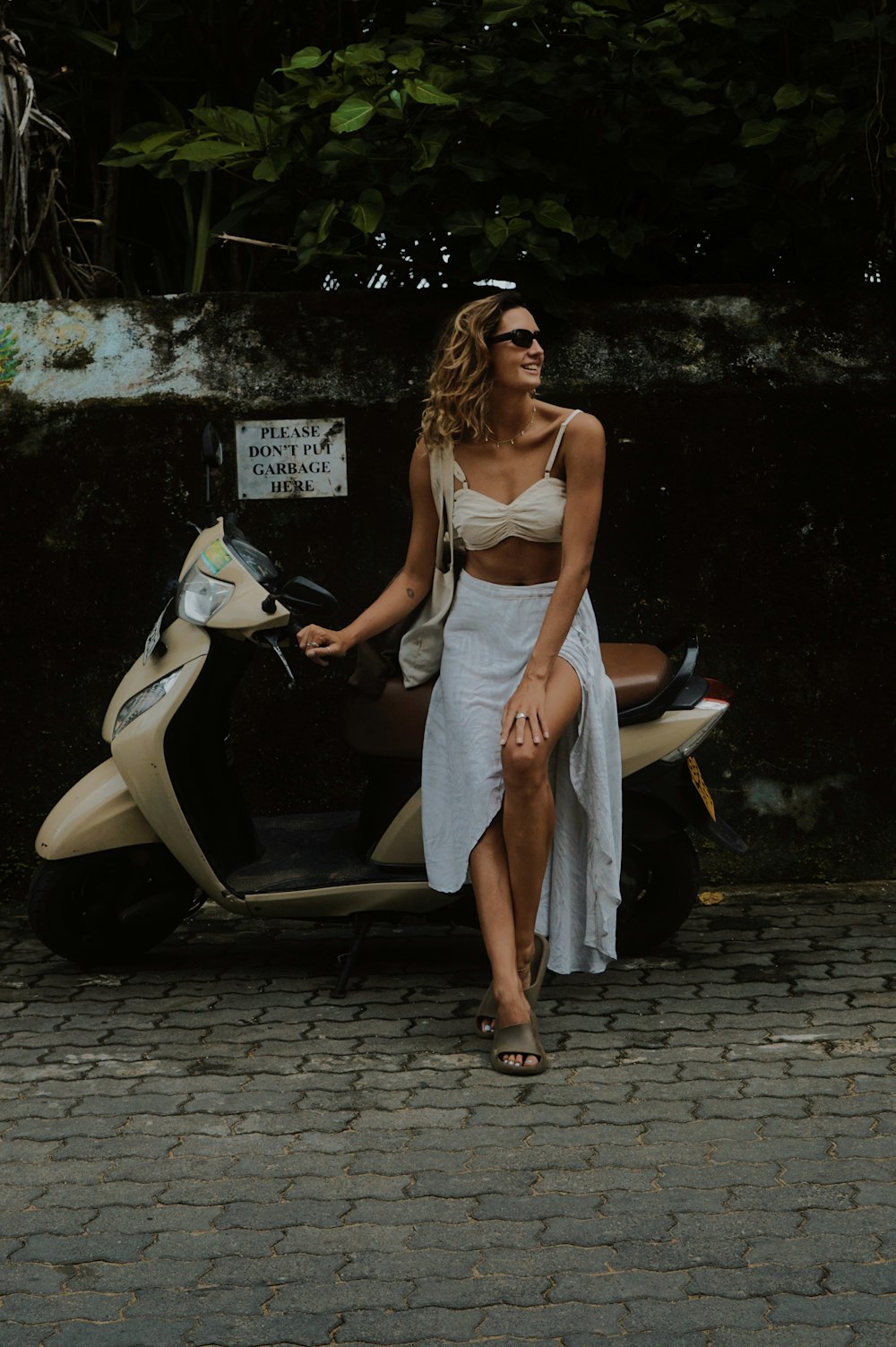 uma mulher em um vestido branco sentado em uma scooter
