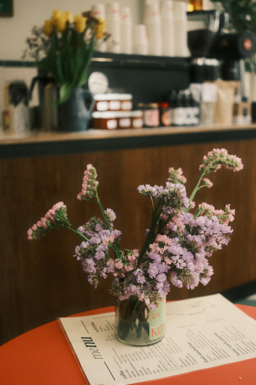 a vase filled with purple flowers sitting on top of a table