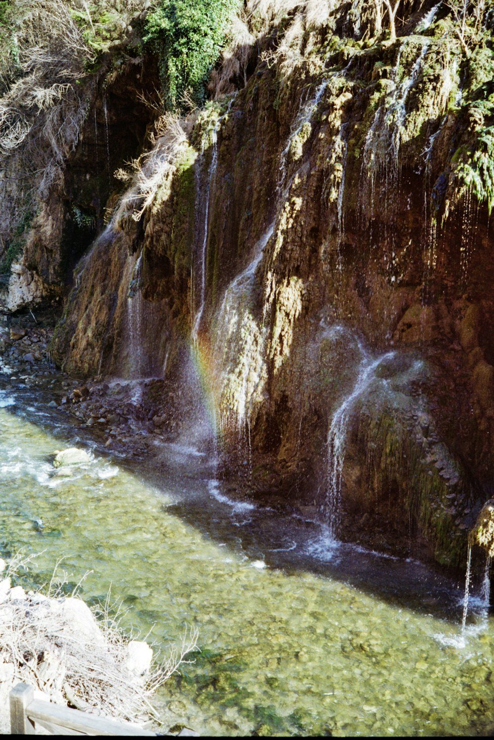 a waterfall with a rainbow in the middle of it