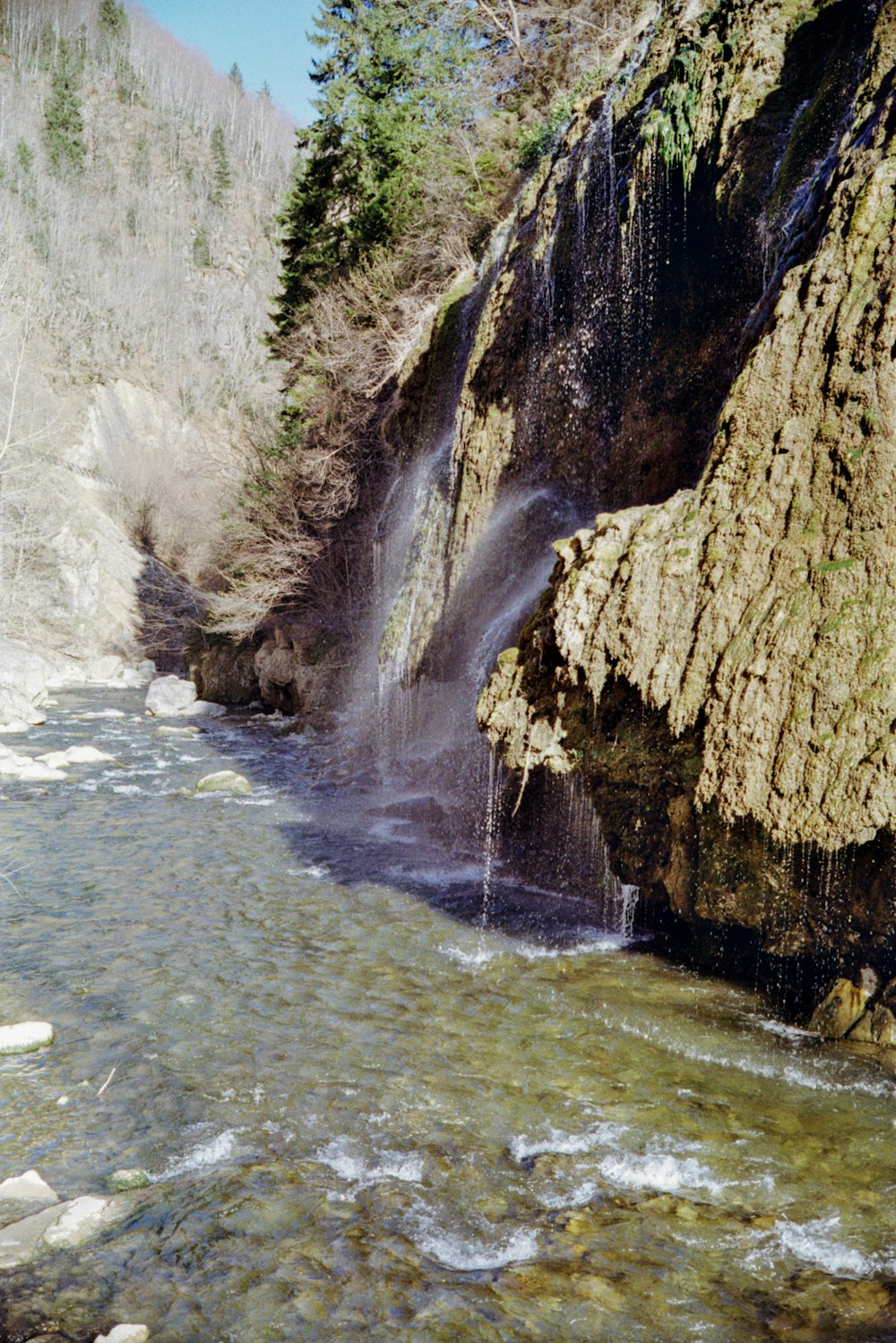 a man standing on a rock next to a river