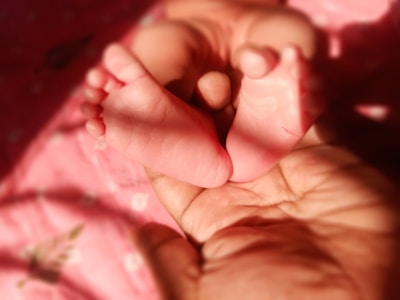 a person holding a baby's foot in their hand