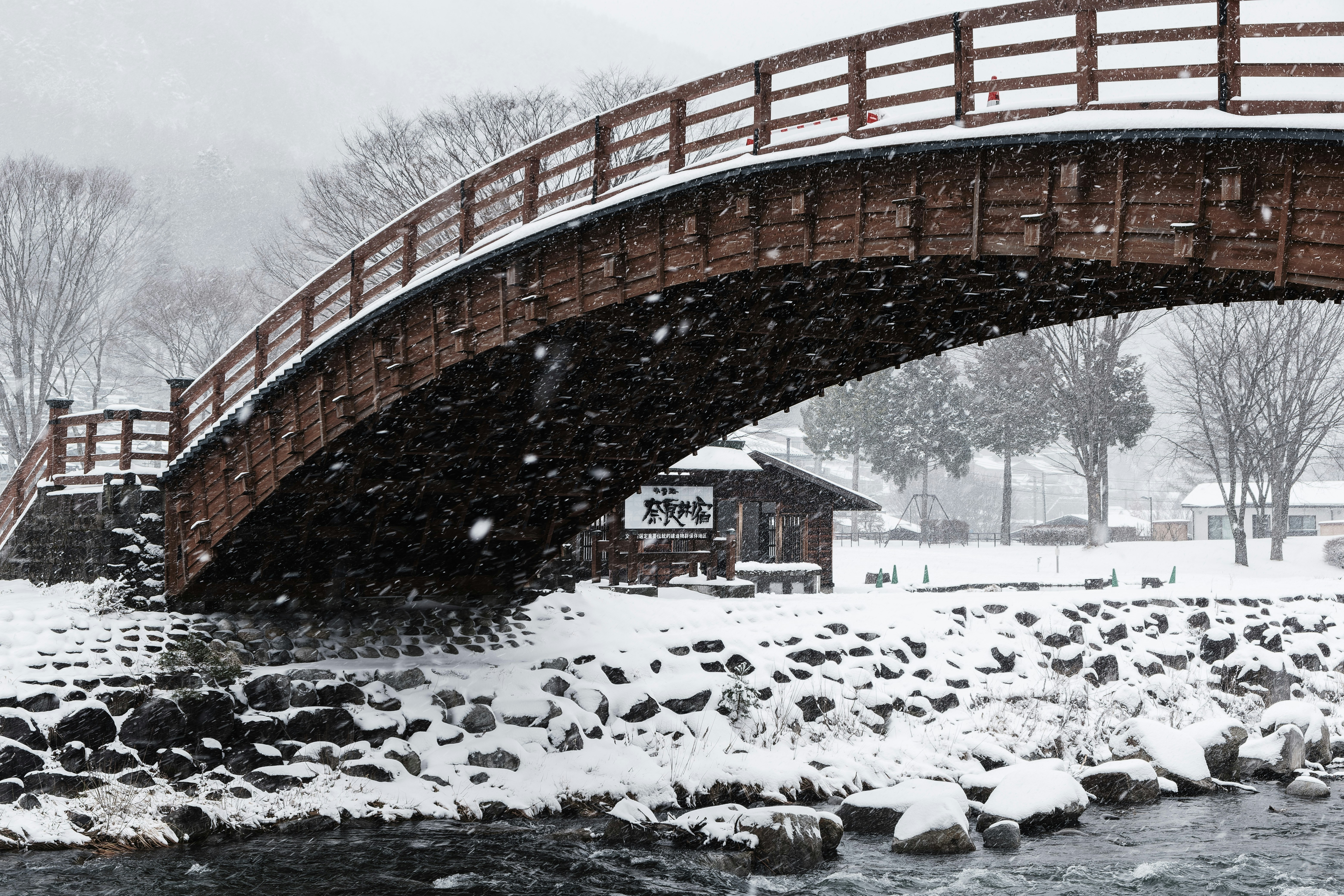 a bridge that is over a river in the snow