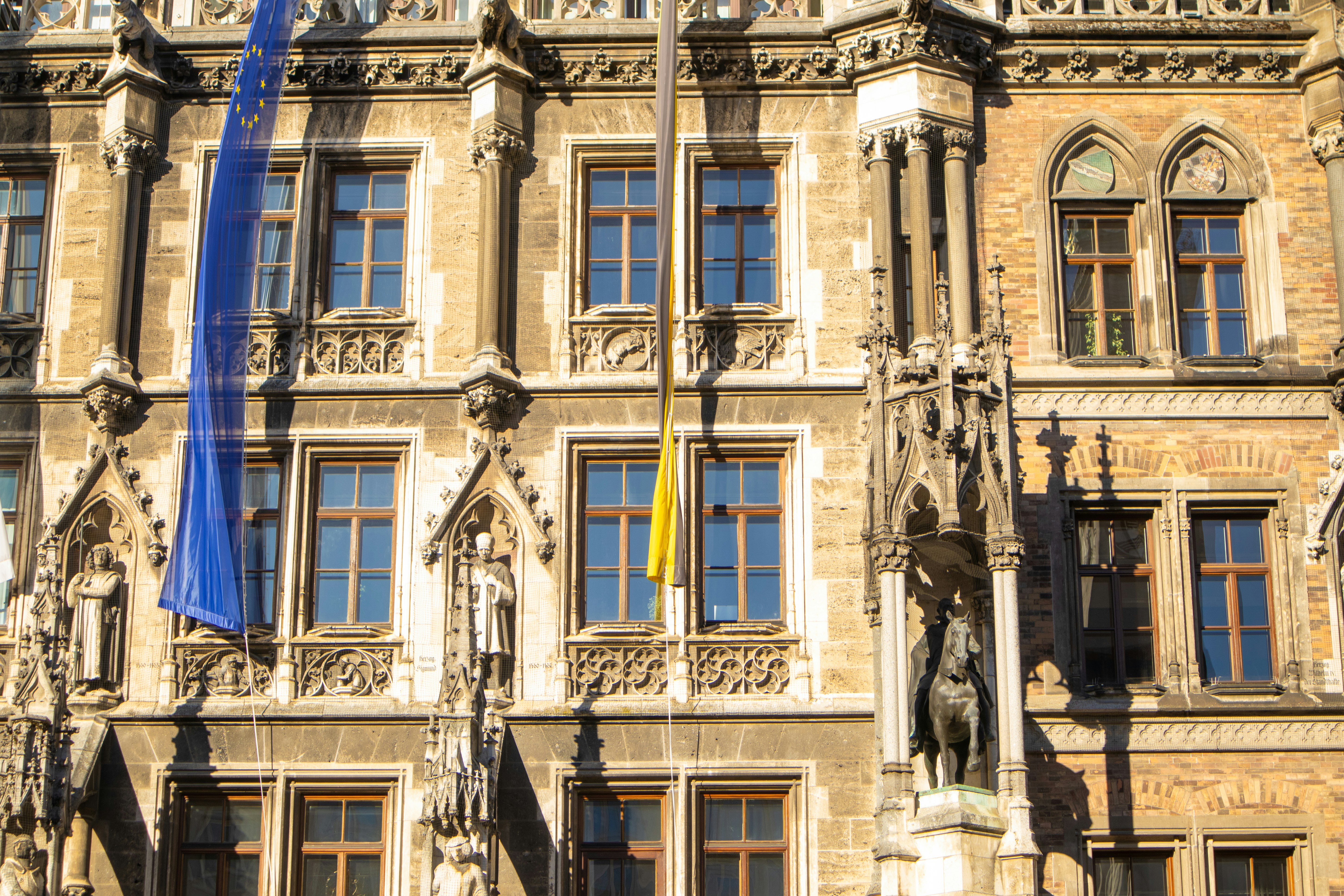 Official government building facade with flags and formal architecture in bright daylight