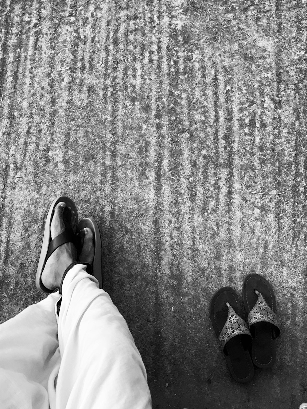 a black and white photo of a person wearing flip flops