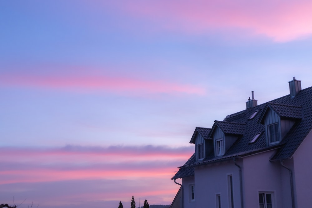 a house with a pink sky in the background