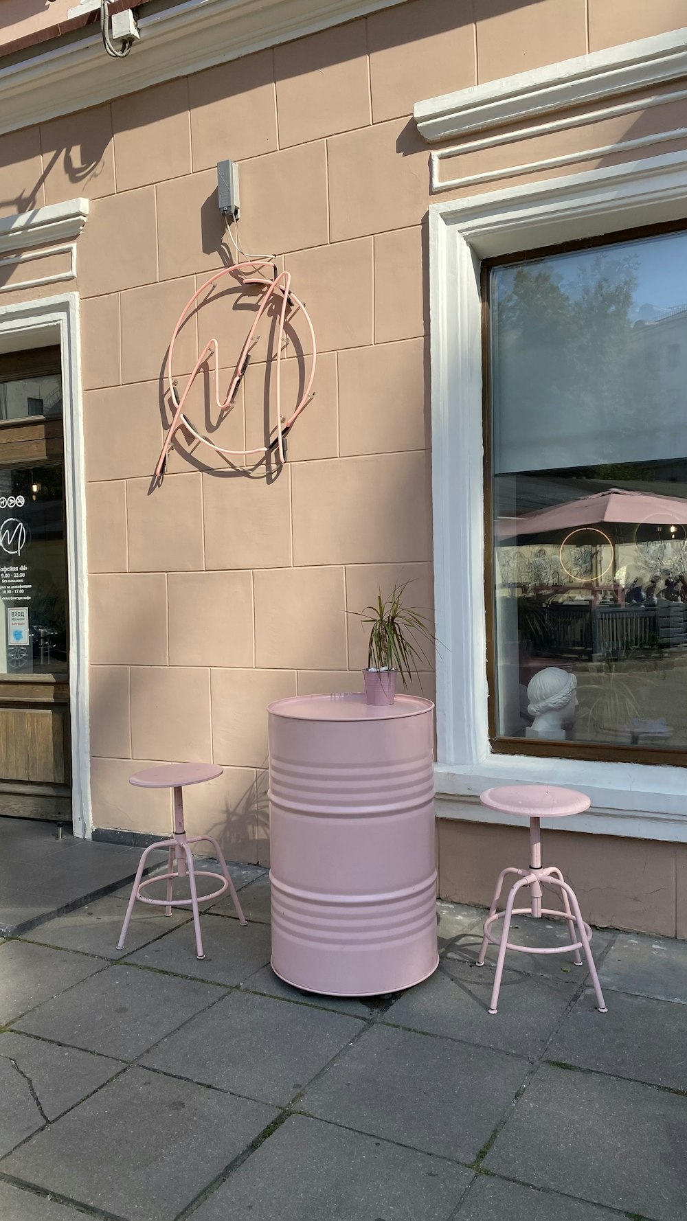 two pink stools sitting outside of a building