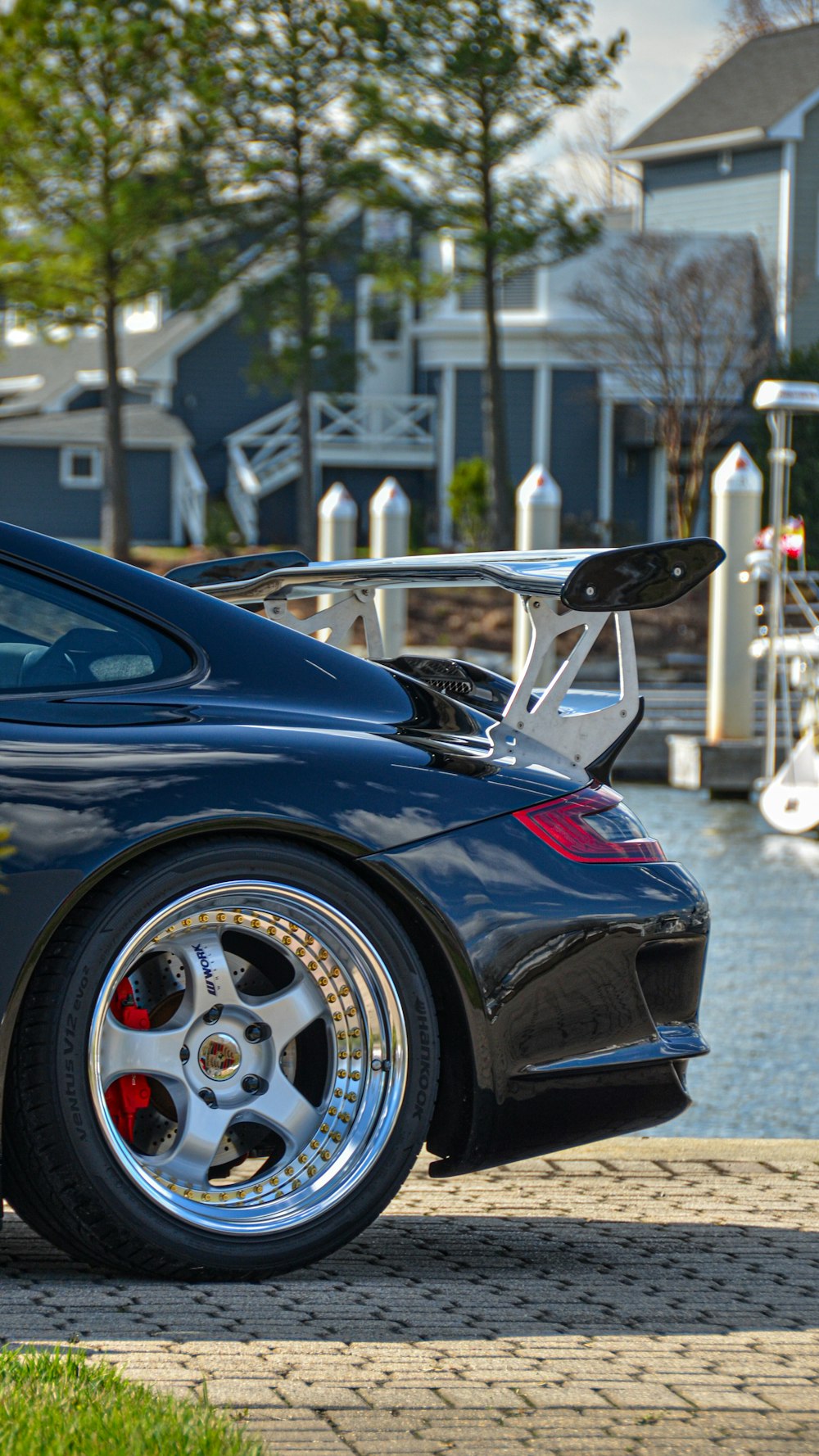 a black sports car parked next to a body of water