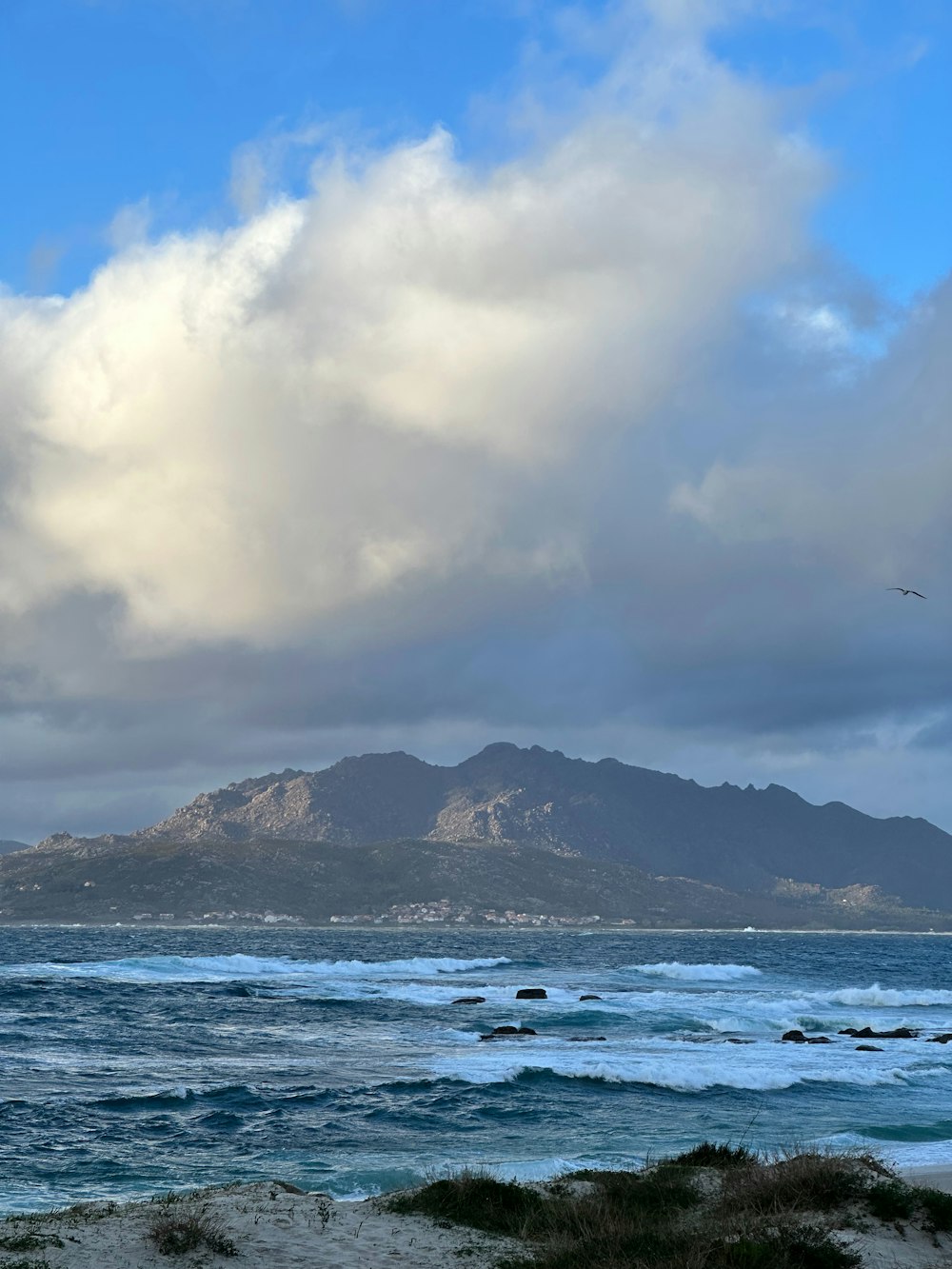 a large body of water with a mountain in the background