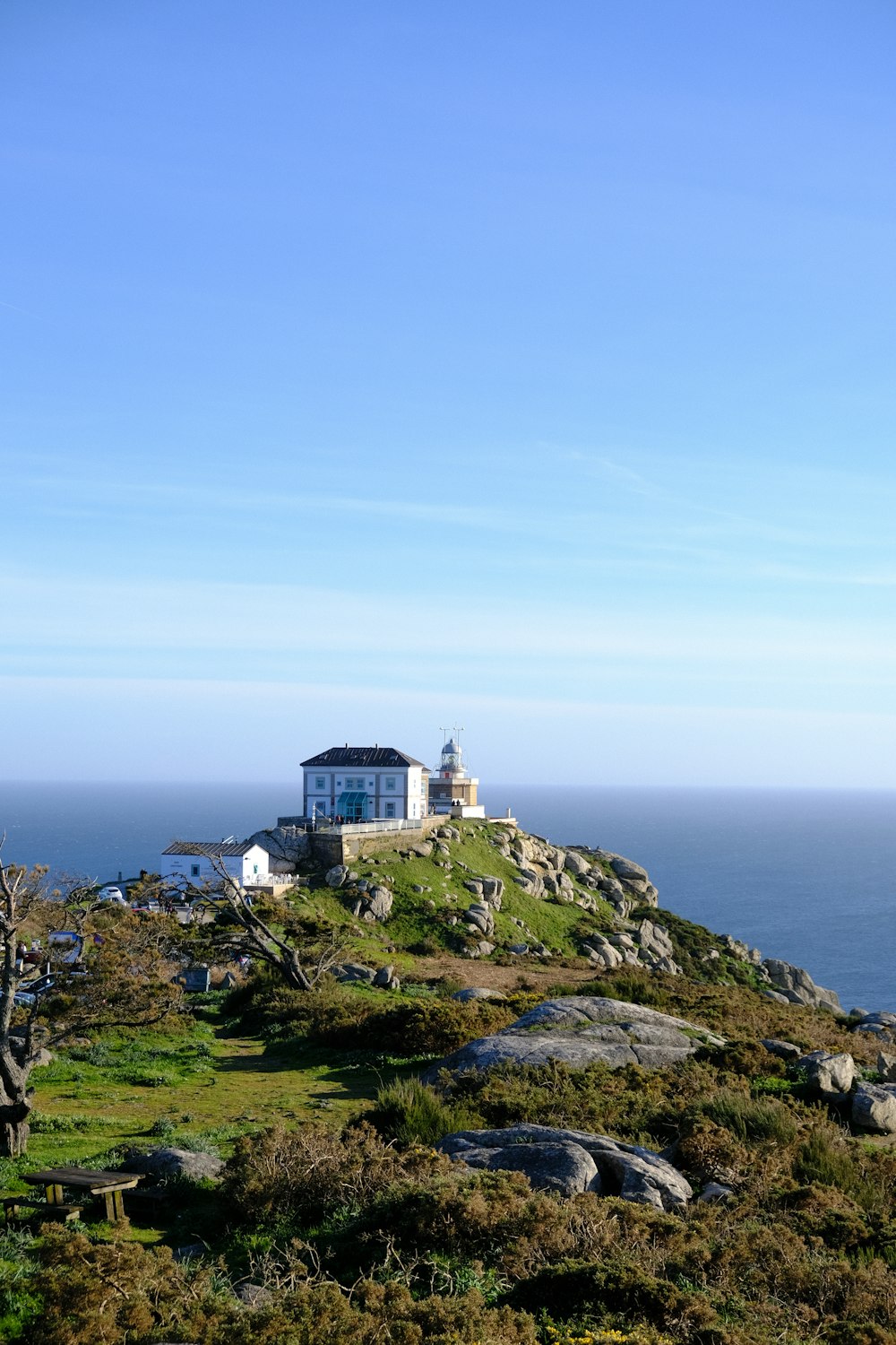 a lighthouse on top of a hill near the ocean