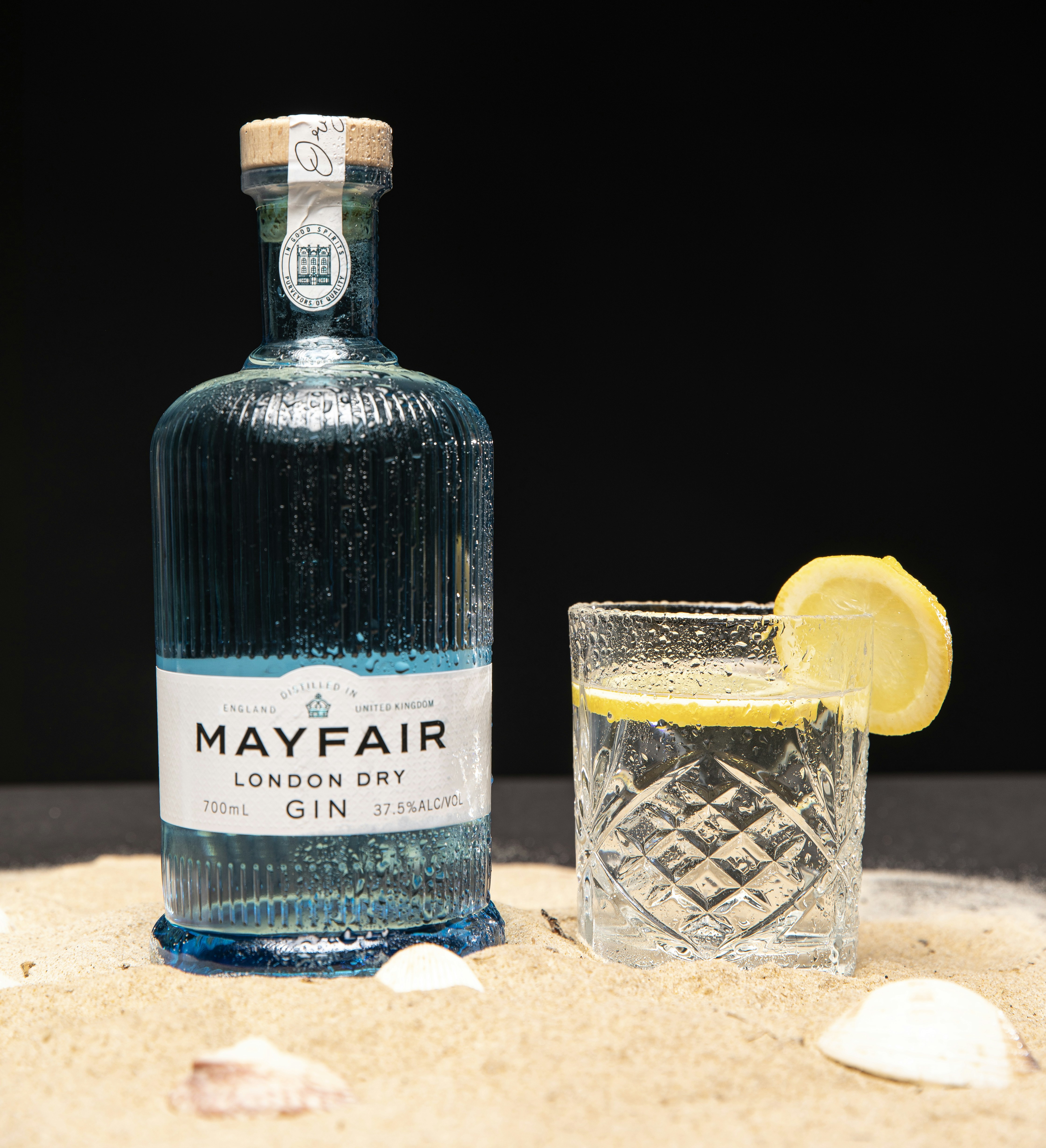 a bottle of mayfair gin next to a glass