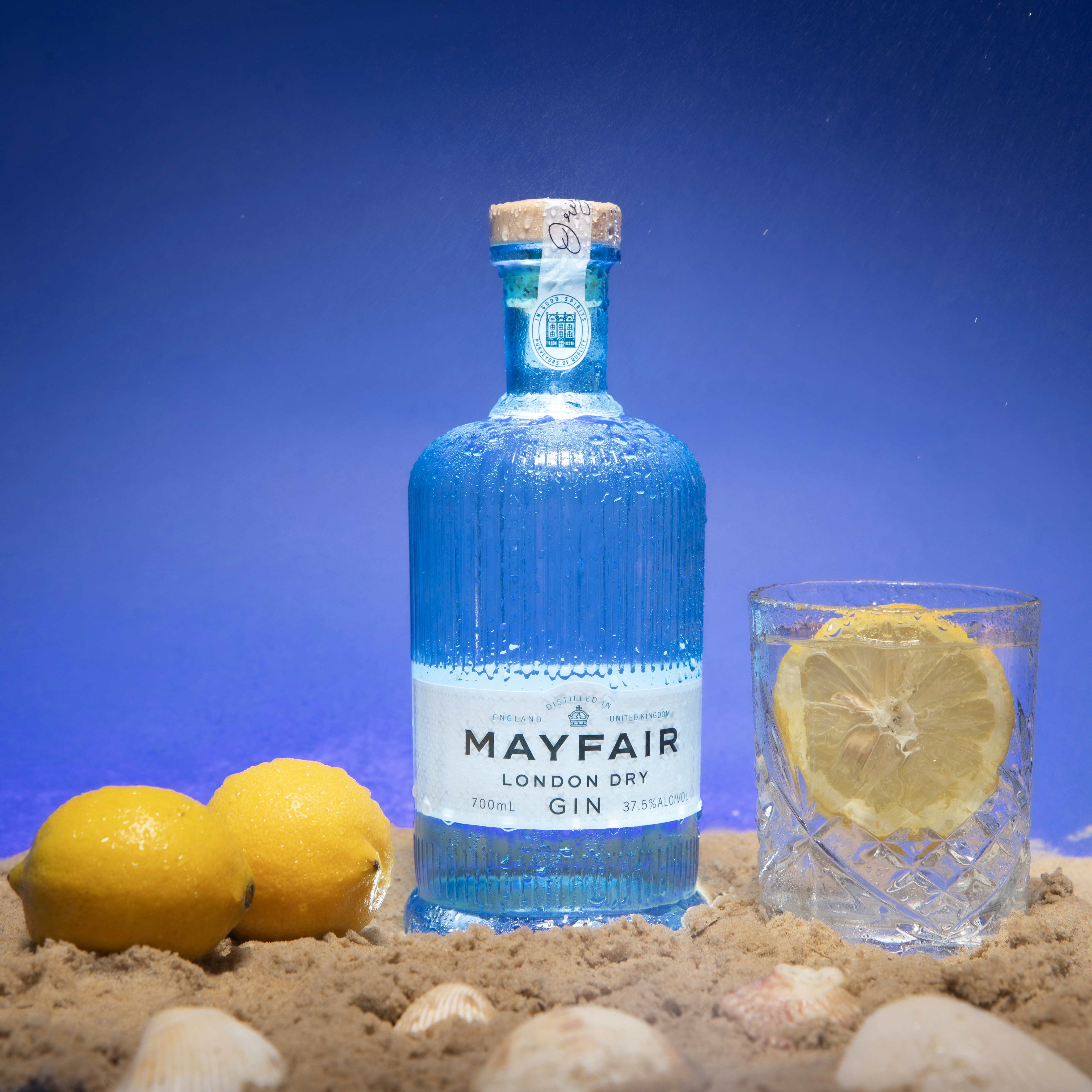 a bottle of may fair london dry gin next to two lemons
