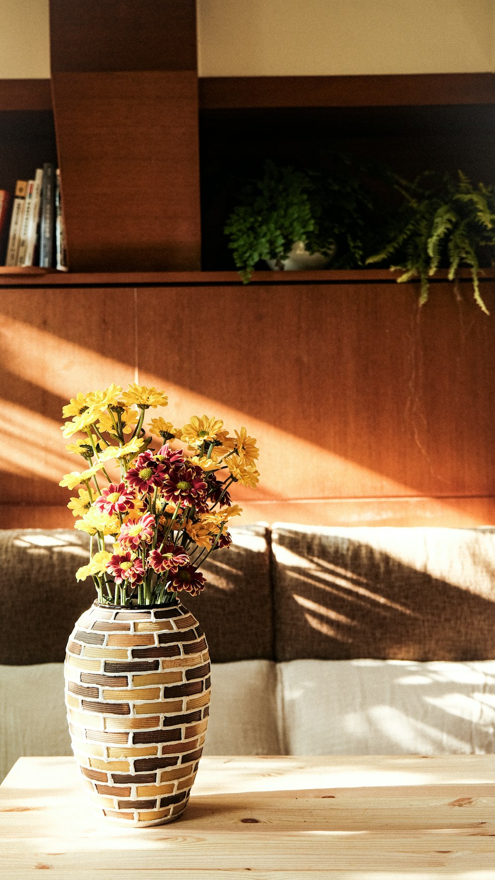 a vase filled with flowers sitting on top of a wooden table