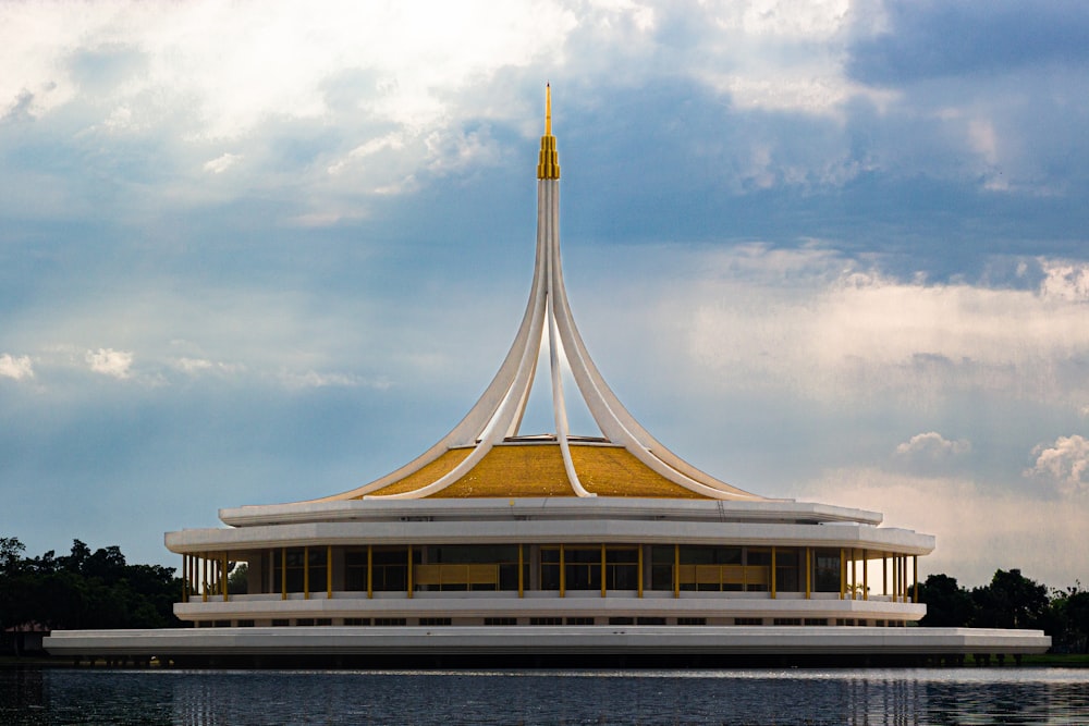 a large white building with a golden top sitting on top of a lake