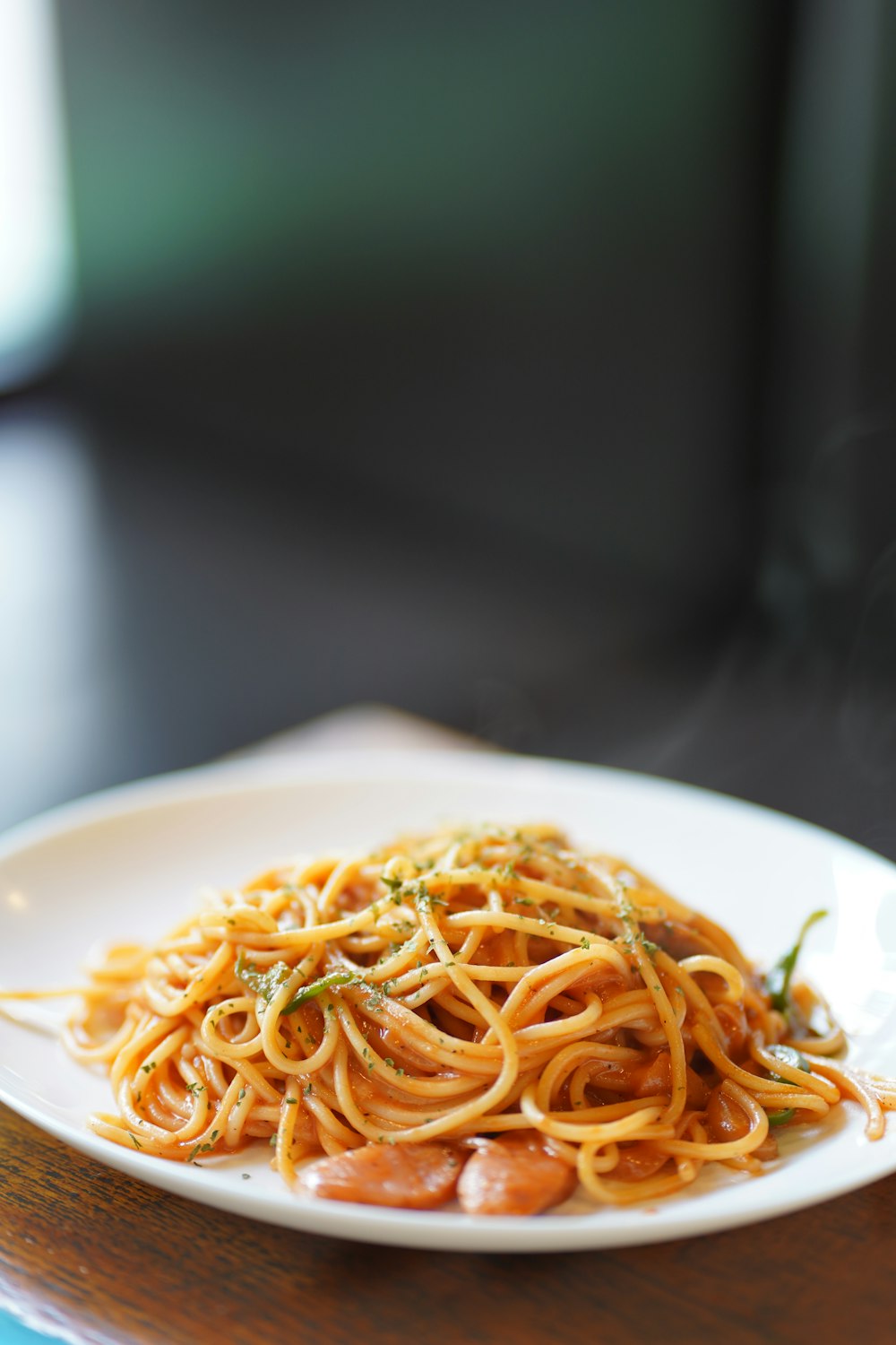 a plate of spaghetti on a wooden table