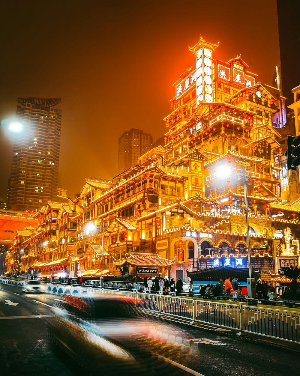 a busy city street at night with tall buildings