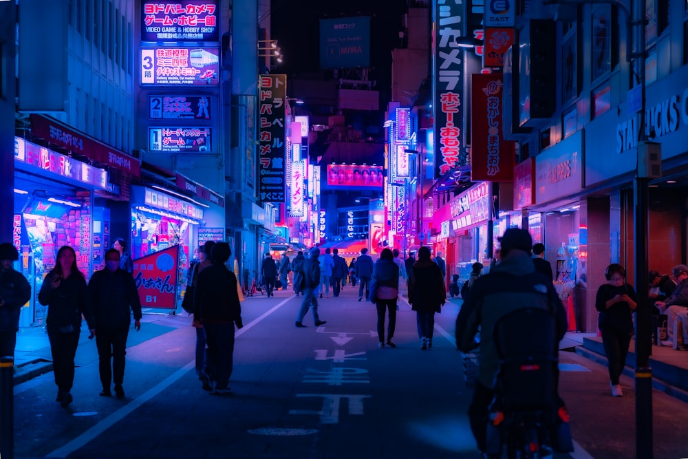 a group of people walking down a street at night