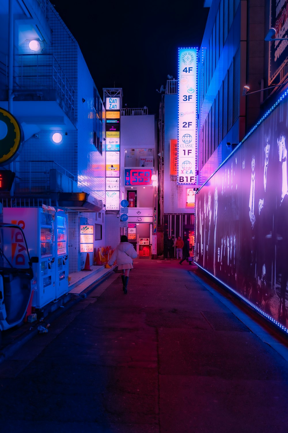 a person walking down a city street at night