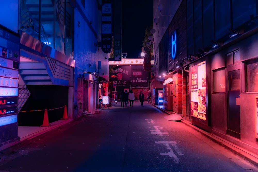 a narrow city street at night with neon lights