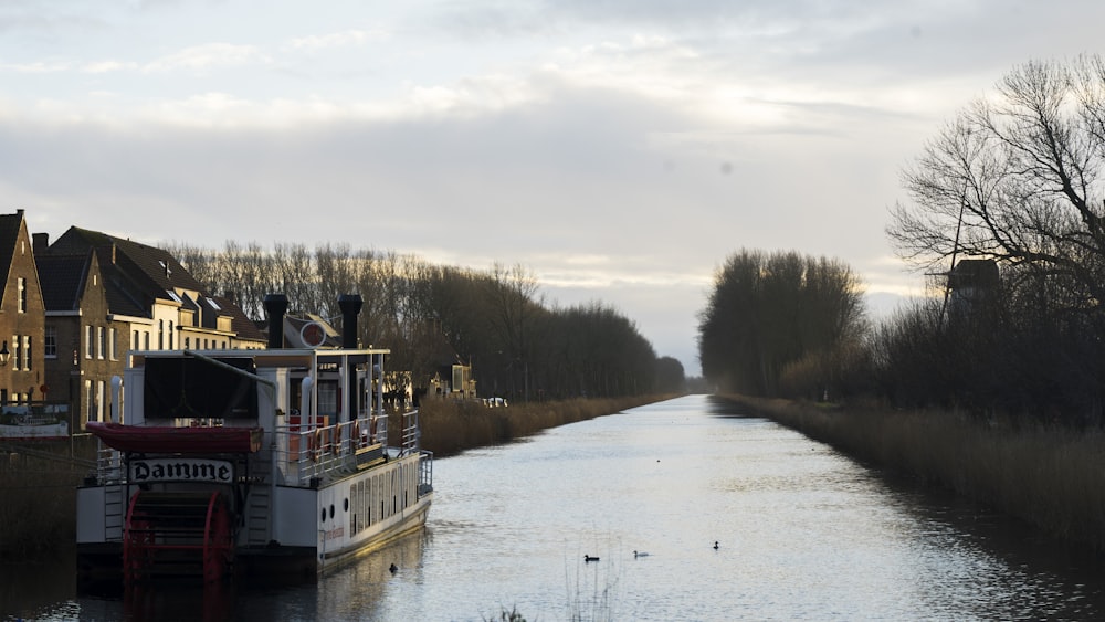 a boat traveling down a river next to a row of houses