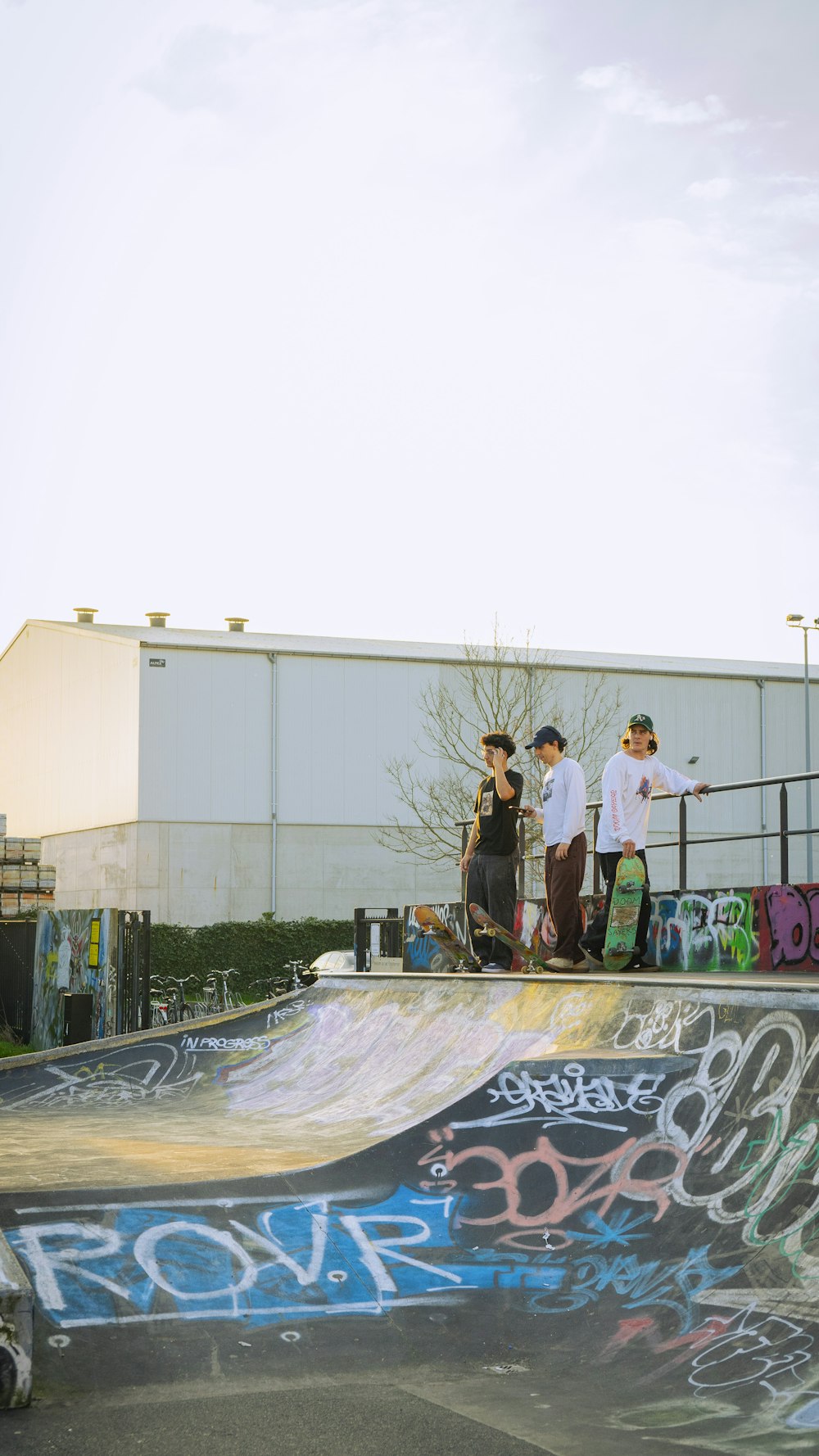 a group of young men standing on top of a skateboard ramp