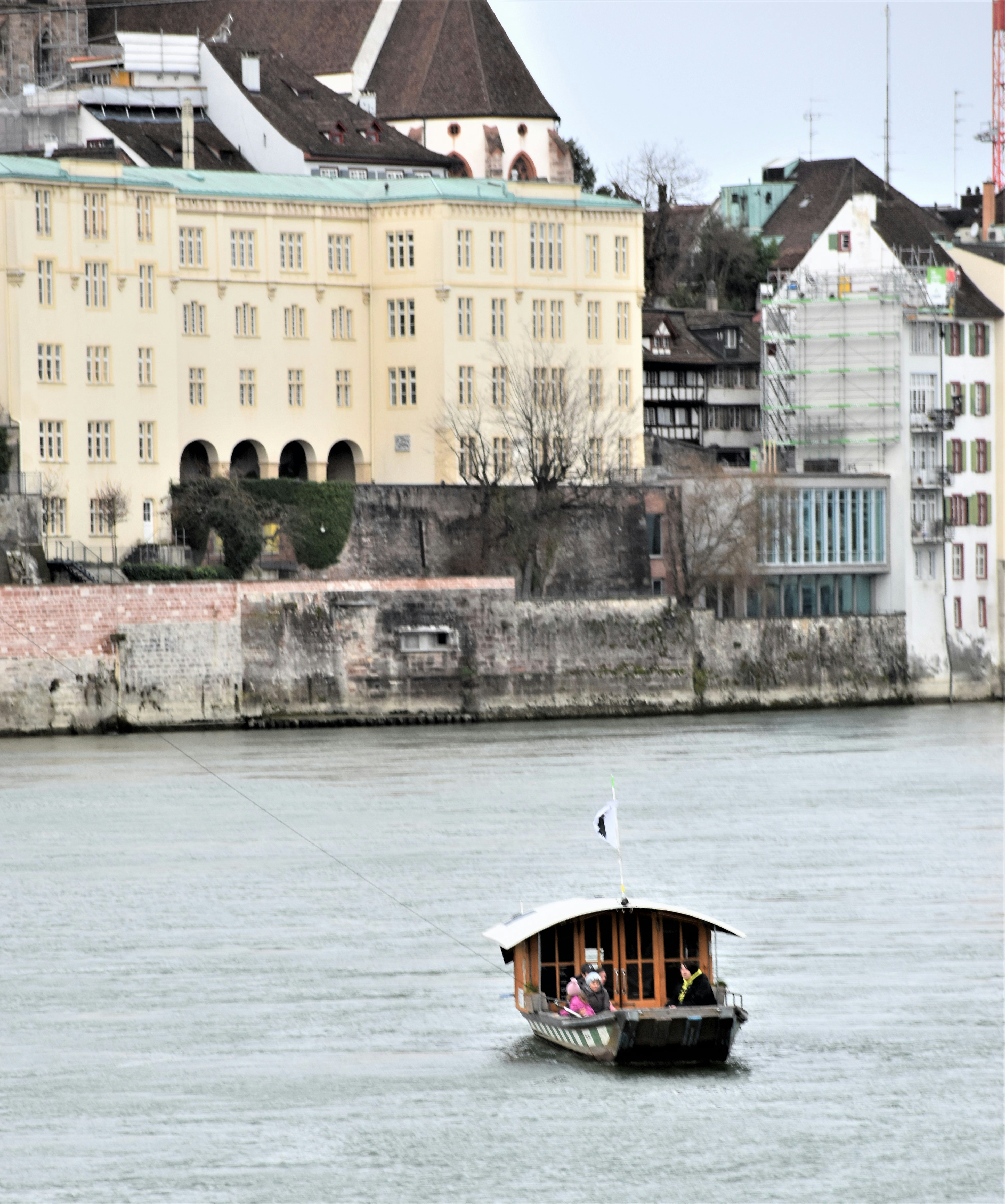 a boat floating on top of a river next to tall buildings
