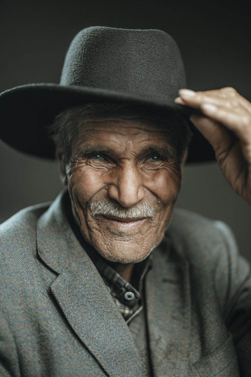 an old man wearing a hat and a suit