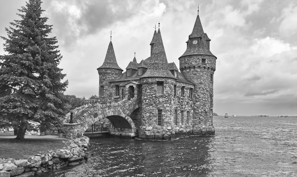 Une photo en noir et blanc d’un château au bord de l’eau