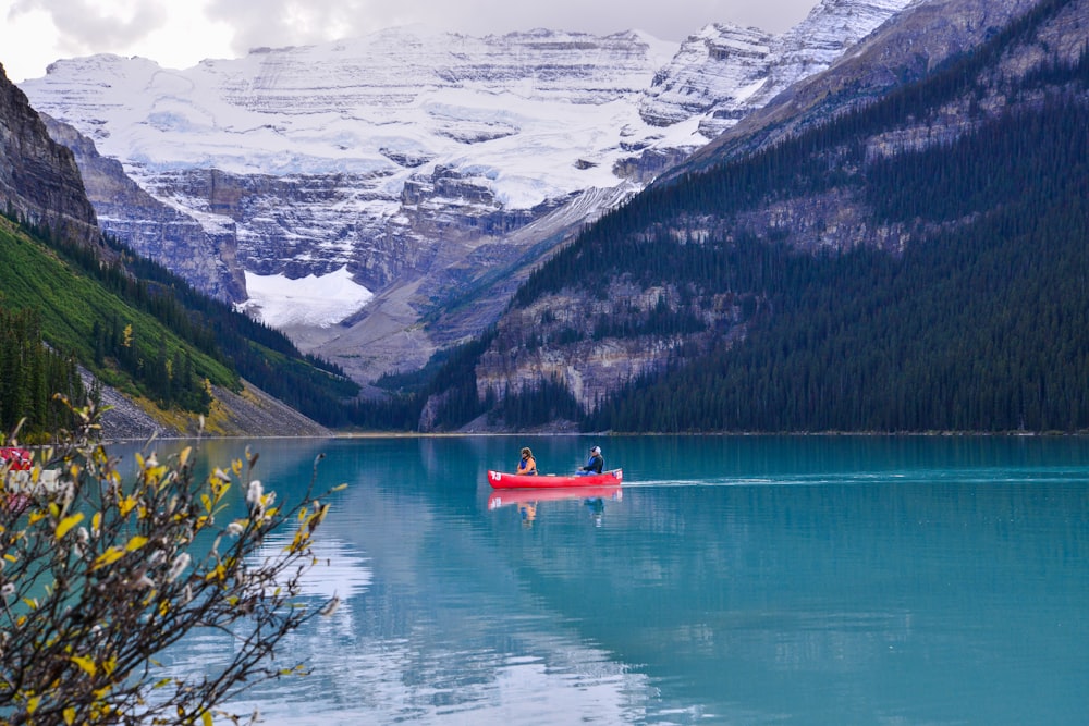two people in a red canoe on a mountain lake