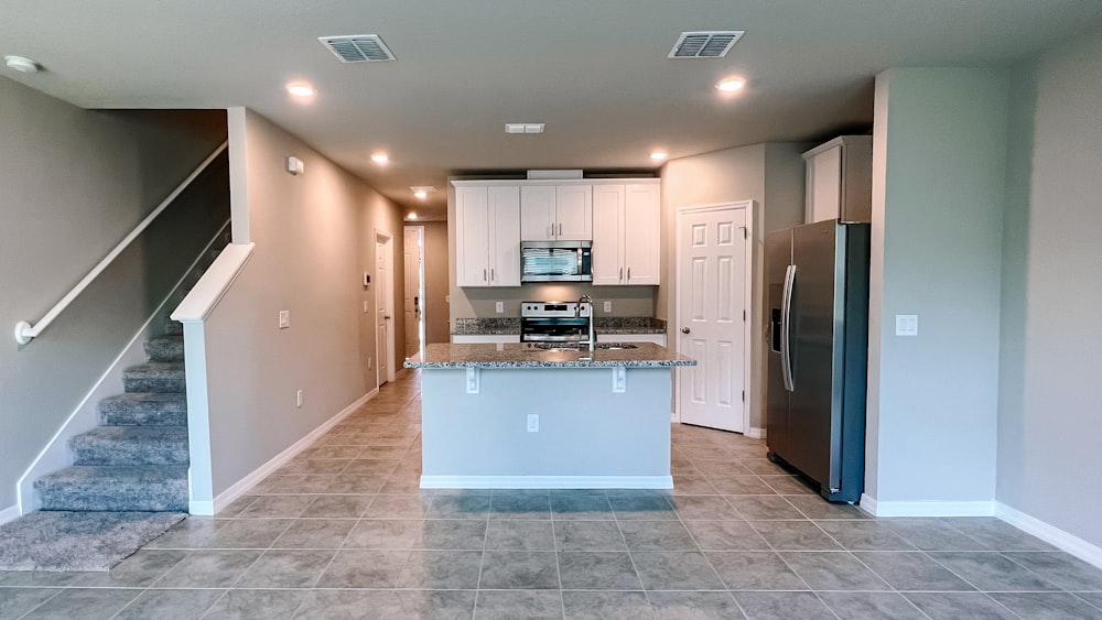 a kitchen with a stove, refrigerator and stairs