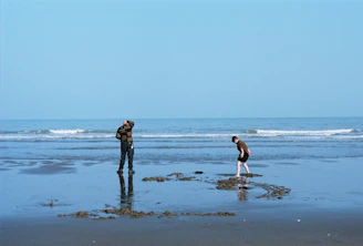 a couple of people standing on top of a beach