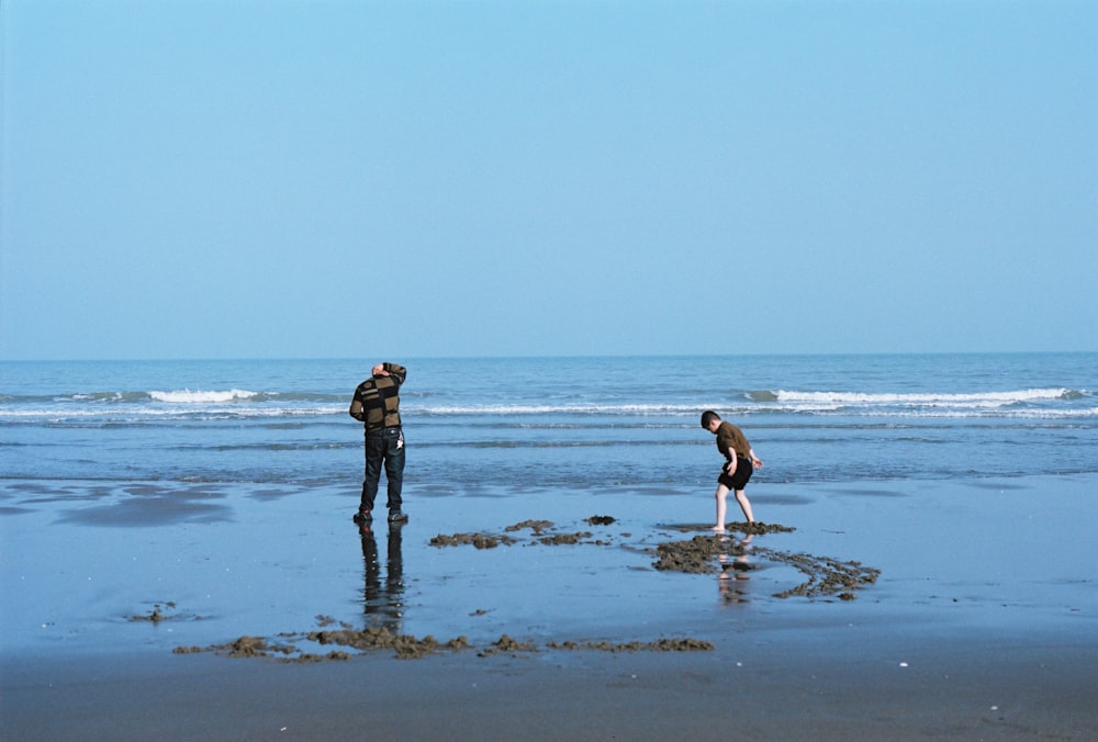 un paio di persone in piedi in cima a una spiaggia