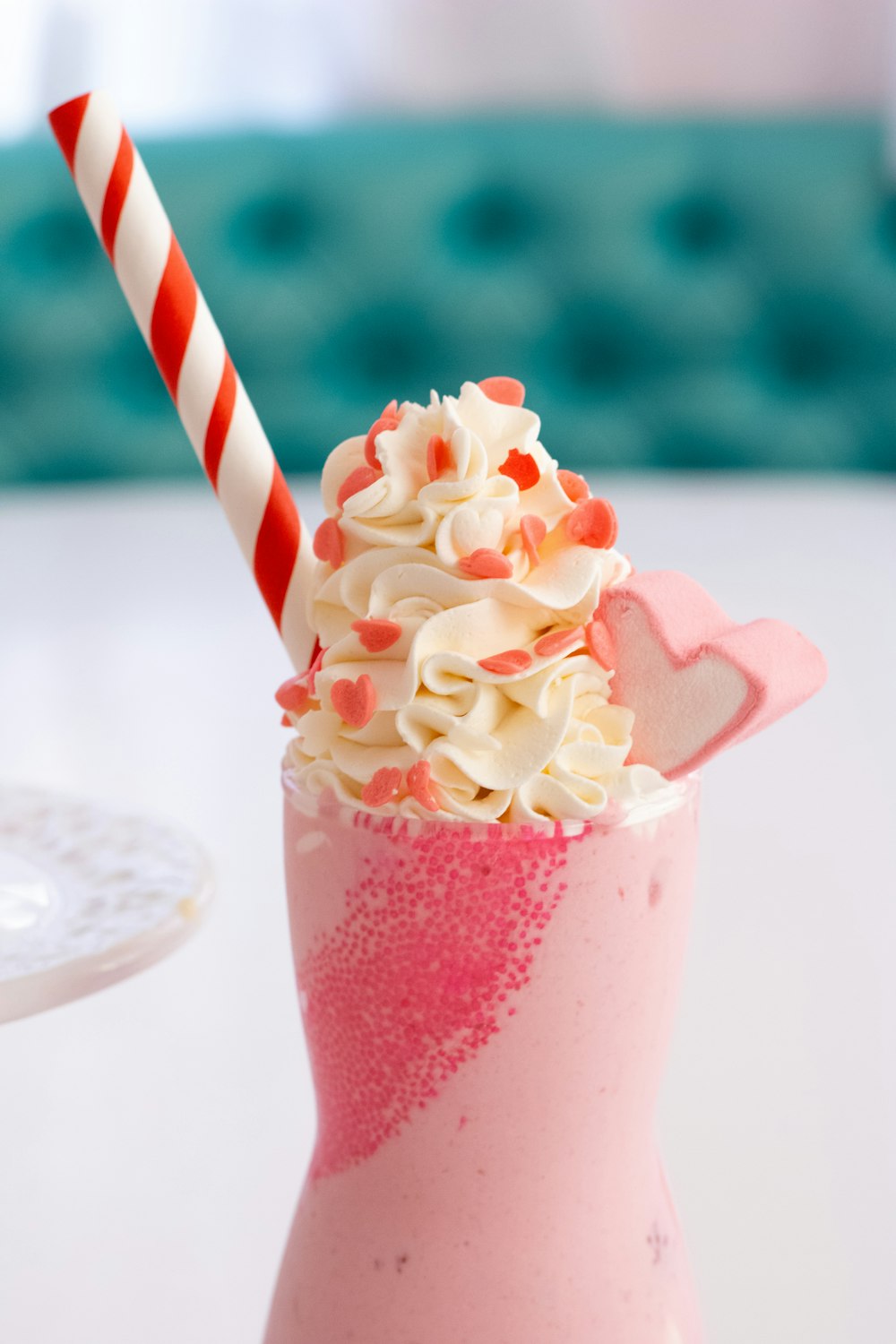 a pink drink with whipped cream and a candy cane