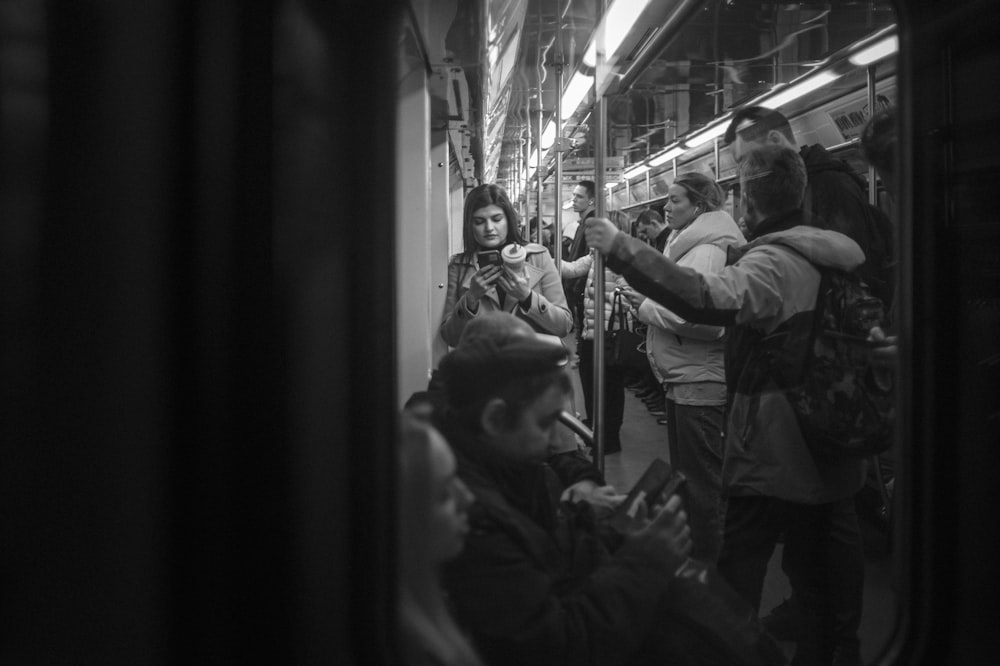 a black and white photo of people on a subway