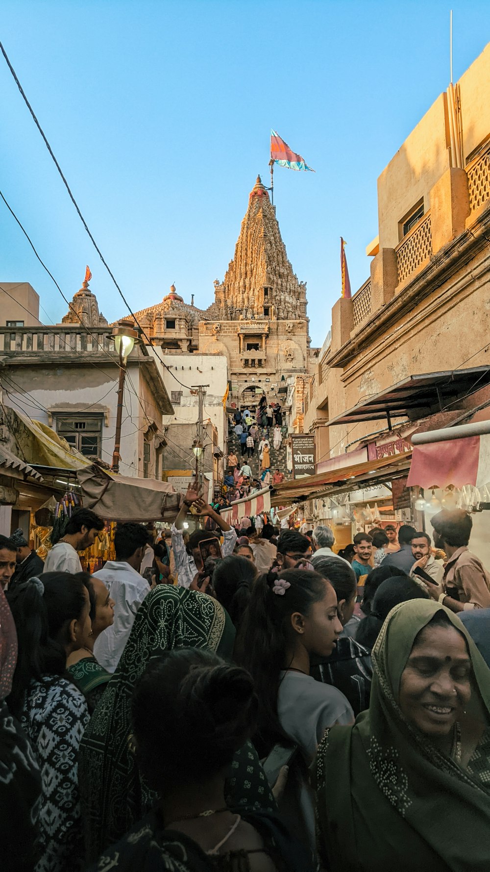 a crowd of people walking down a street next to tall buildings