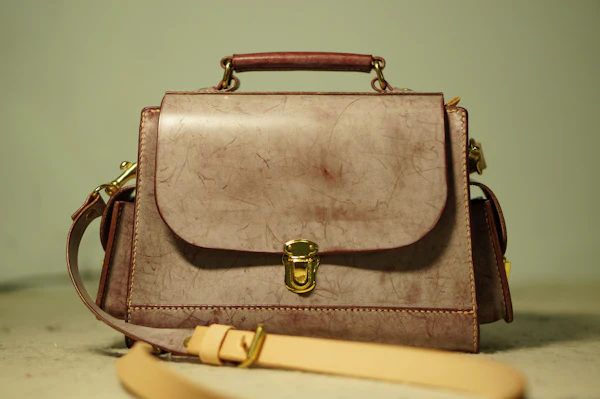 Bolso de cuero café con broche dorado