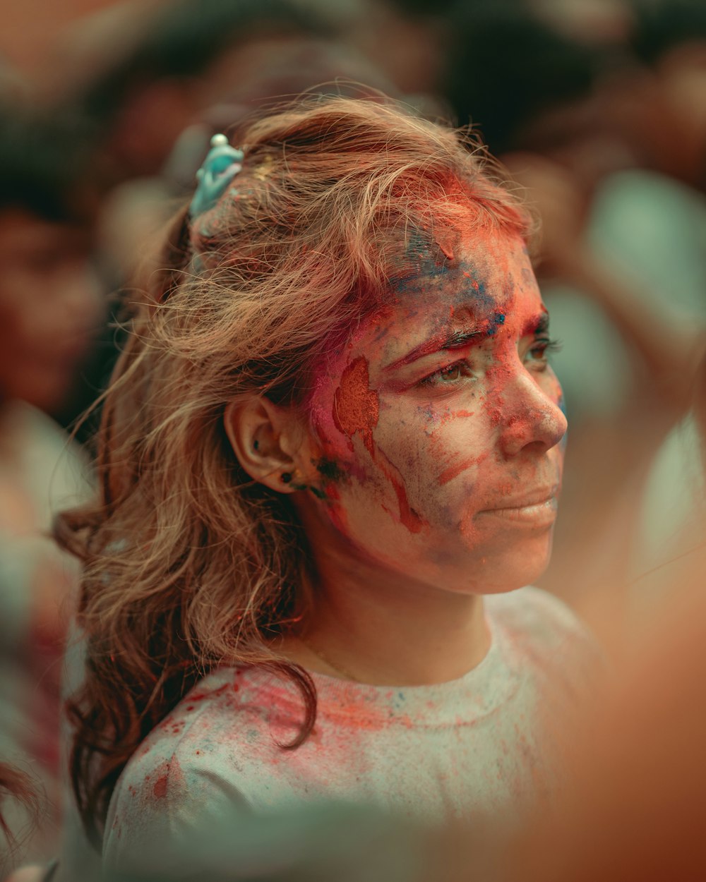 a young girl covered in red and blue paint