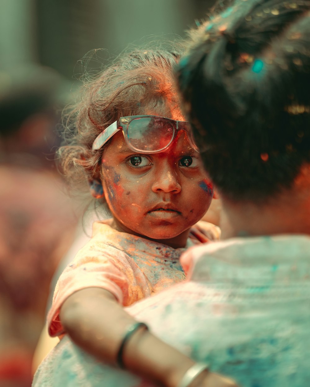 a little girl with her face covered in paint