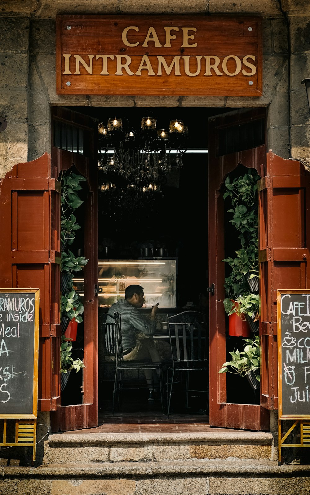 a man sitting at a table in front of a restaurant