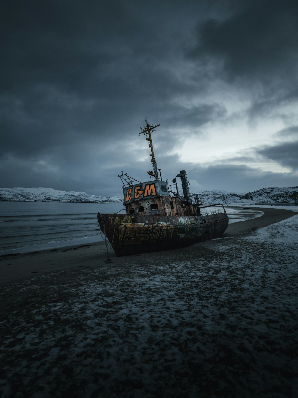 a boat sitting on top of a sandy beach