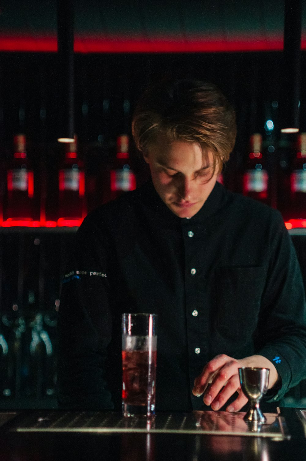 a man sitting at a bar with a drink in front of him