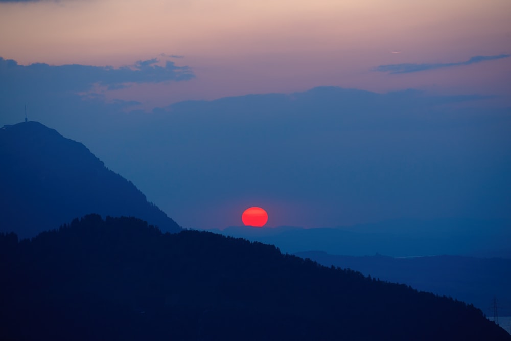 the sun is setting over a mountain range