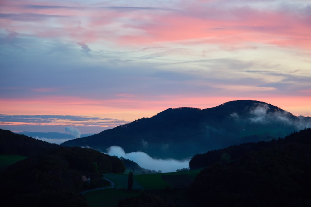 a view of a mountain range with clouds in the sky