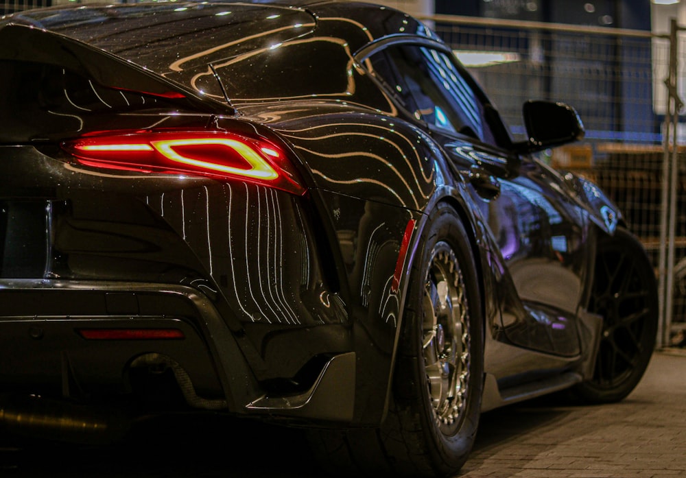 a black sports car parked in a parking lot