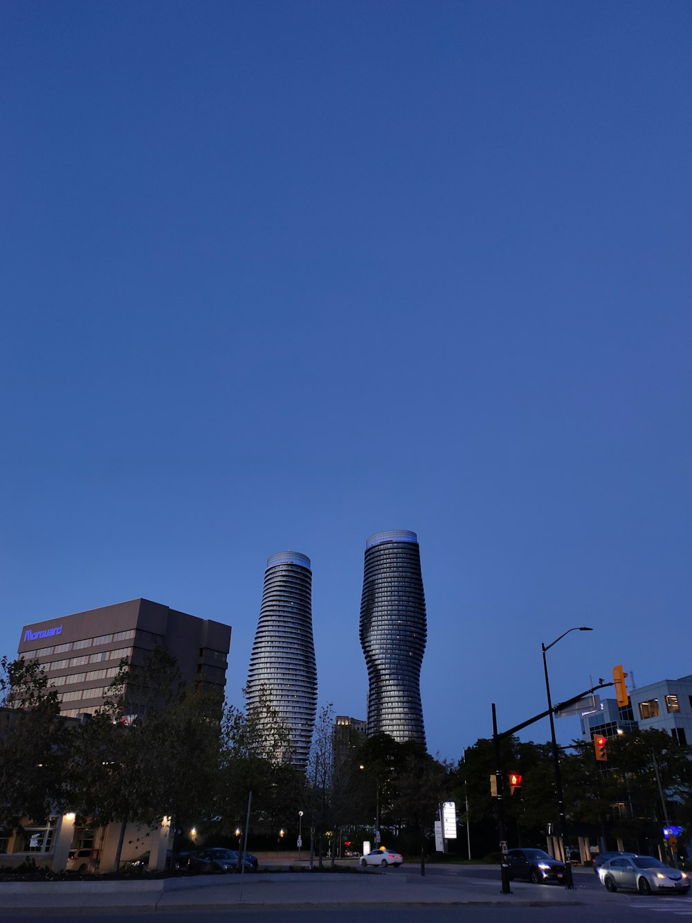 a couple of tall buildings sitting on the side of a road