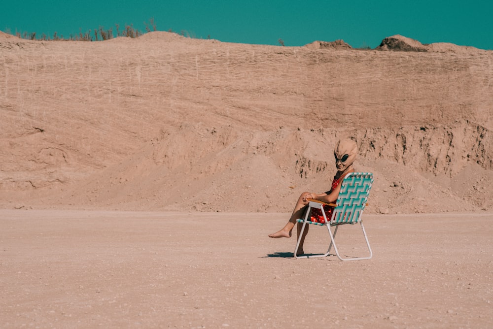 a person sitting in a chair in the desert