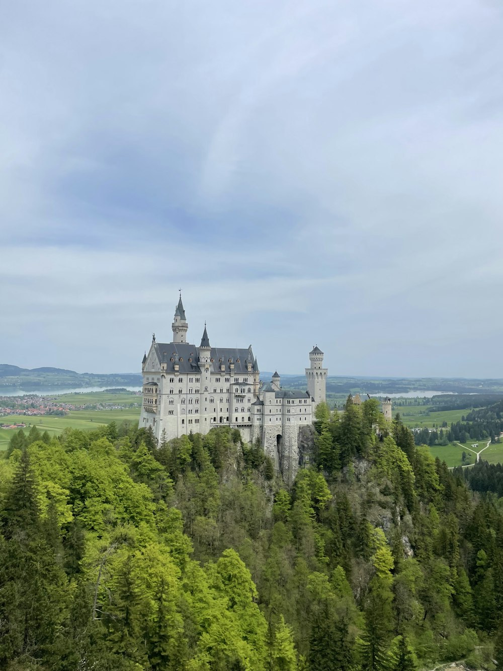 a large castle sitting on top of a lush green hillside