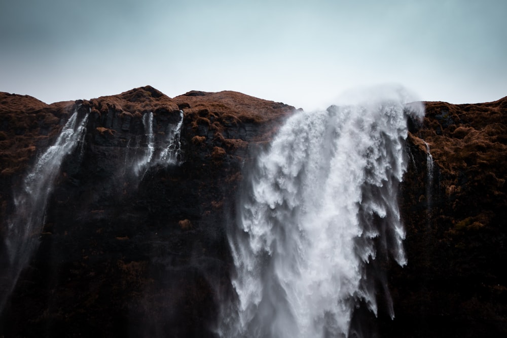 a very tall waterfall with lots of water coming out of it