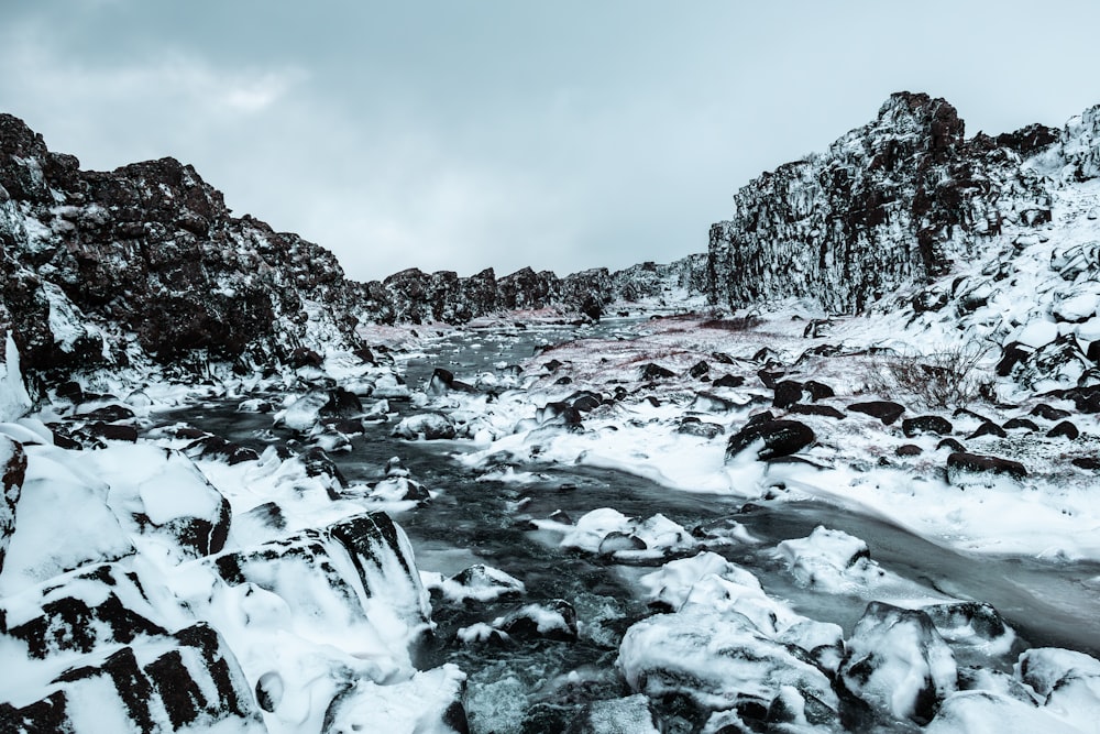 a river running through a snow covered rocky landscape
