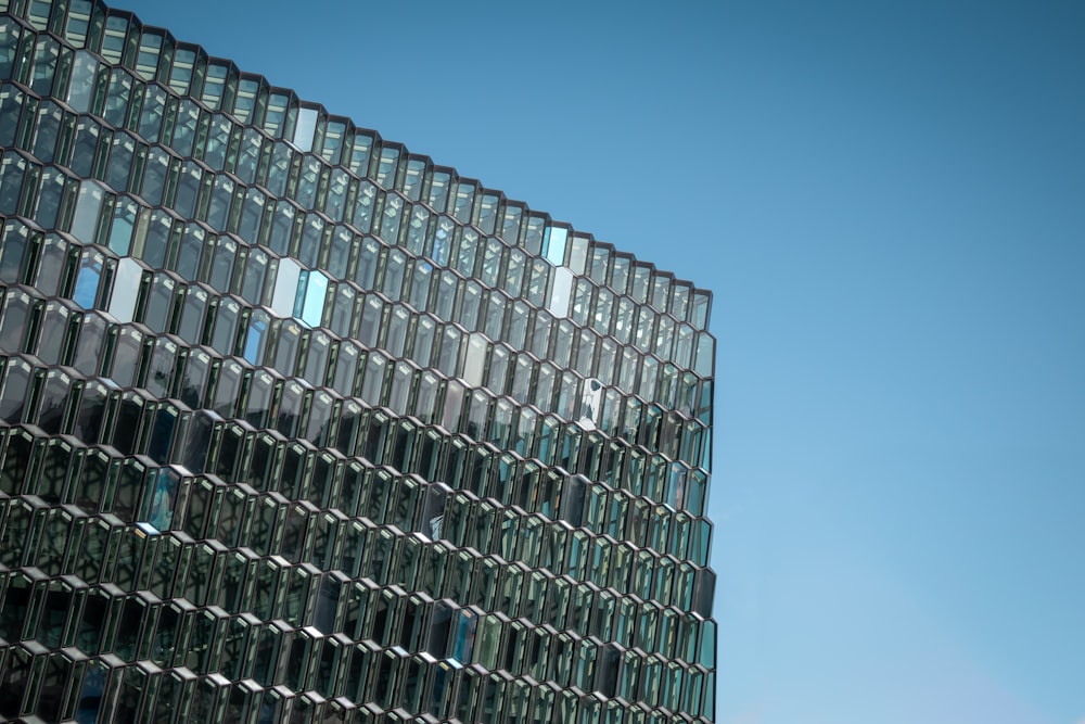 a very tall building with many windows next to a blue sky