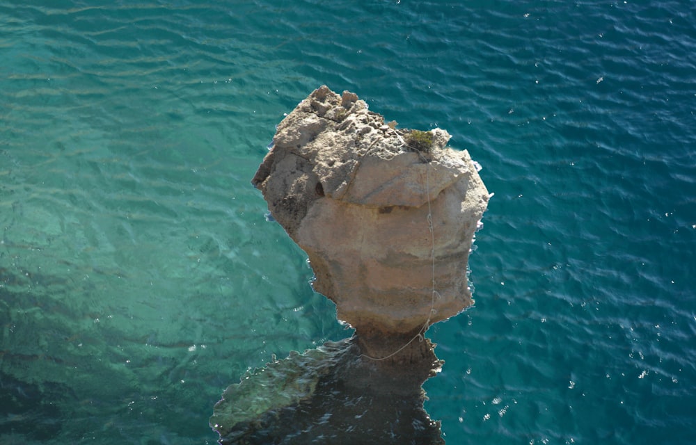 a large rock sticking out of the water